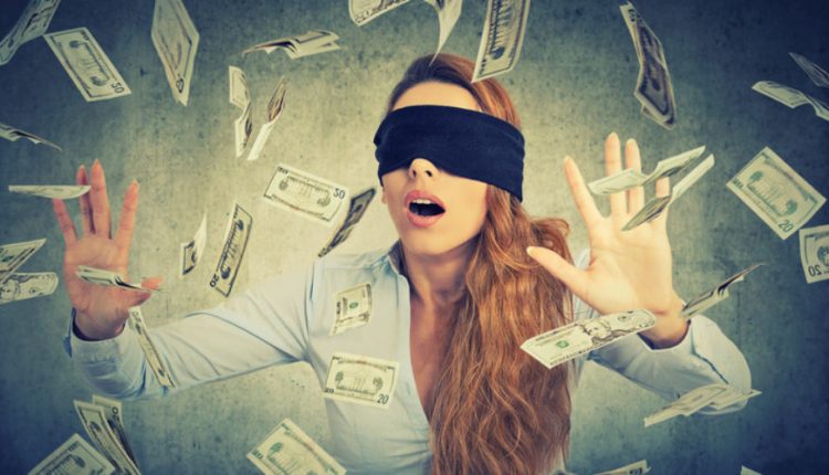 Blindfolded entrepreneur businesswoman trying to catch dollar bills